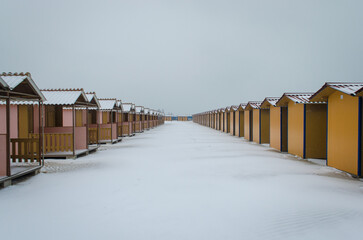 I capanni di uno stabilimento balneare del Lido di Venezia coperti dalla neve in una fredda giornata invernale  - obrazy, fototapety, plakaty