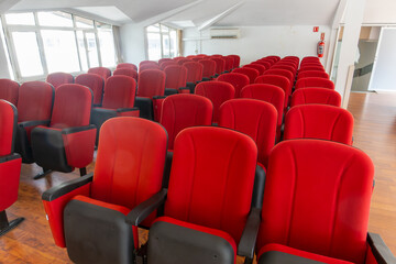 Stylish red chairs. Rows of red chairs arranged in the main conference room.

