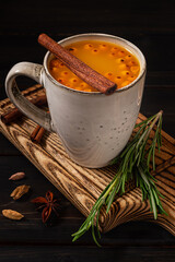 A cup of sea buckthorn hot drink on dark wooden background