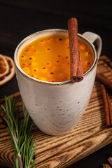 A cup of sea buckthorn hot drink on dark wooden background