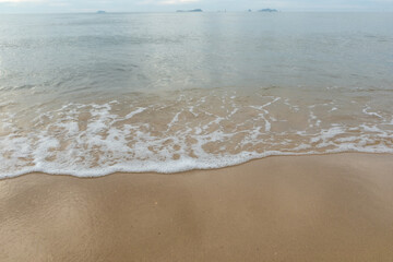 Fototapeta na wymiar Beautiful beach with the smooth foam of sea in the morning of Rayong province Thailand