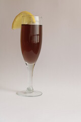 Copa de cristal transparente para brindis de celebraciones,  con bebida alcohòlica y rodaja de limòn para tragos en el bar, forma un bello y original diseño con fondo blanco