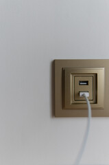 usb charging built into the wall with a wire. wired device charging via usb. charger cord close-up...