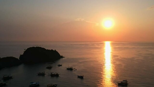 Morning on the beach in the village of Cirali, fishing nets lie on the yellow sand. Boats and ships in the distance of the Taurus mountain are moored near the shore. Landscapes of the Lycian Trail.