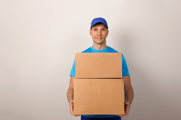 Portrait of handsome attractive cheerful delivery man holding card-board box. Express delivery service. Copy space.