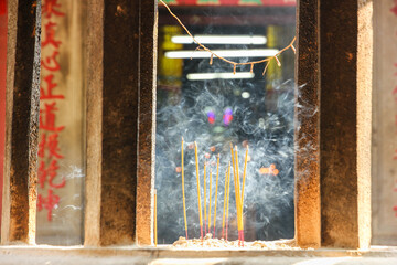 Smoke from incense sticks lit at a shrine in the ancient Jade Emperor's Pagoda in the city of Saigon.