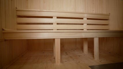 Sauna room with traditional sauna accessories for healthy. Interior of an empty modern sauna in a hotel or in a spa. Benches in the sauna inside.