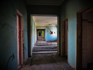 Blue and green corridor in old abandoned hotel building, urban exploration