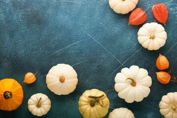 Halloween festive autumn background. Autumn decor from pumpkins, berries, maple leaves and chestnuts on old scratched blue backgrounds. Concept of Thanksgiving day Halloween. Top view copy space