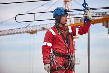 A specialist repairs an antenna on the roof. Rope access