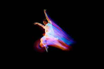 Dance in motion. Studio shot of flying, jumping dancer or gymnast performing tricks in the air over...