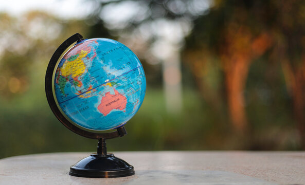 globe on white table in soft green nature background,Concept of global business study abroad education.