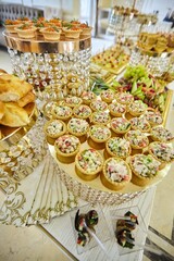 Assorted canapes and various delicacies on the festive table. Snacks for guests at the event.