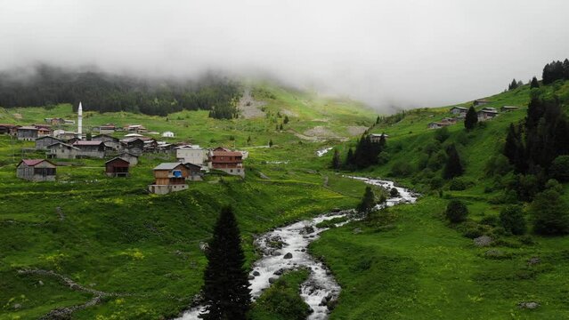 Rize aerial view in foggy weather. Drone video over houses with a red roof, a mountain river flows nearby in Elevit, Turkey