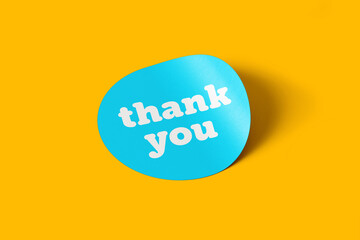 Thank you message on rounded sticker note paper with yellow background