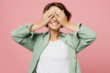 Young satisfied amazed happy woman wear green shirt white t-shirt cover eyes with hands like...