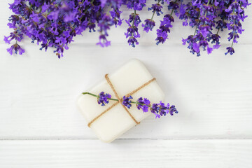 Fototapeta na wymiar Natural cube of lavender soap on white wooden background