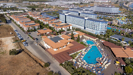 Aerial drone photo of the beautiful town of Alanya, a resort town on Turkey’s central Mediterranean coast showing a hotel and vacation holiday resort swimming pool from above in the summer time.