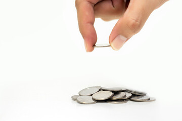 Man hand holding coin with A pile of coins on isolated white background, Money growing concept and sustainable investment, Business success and financial concept,  Banking and economy idea 