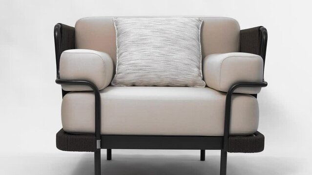 Beautiful upholstered designer armchair with voluminous pillows made of light textiles. White background. Isolated