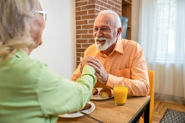 Senior couple eating breakfast at home.