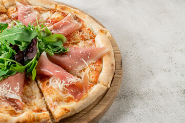 Meat pizza with ham and cheese on the white concrete background