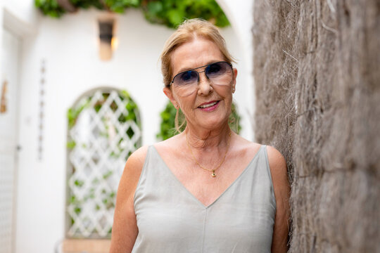 Portrait of senior mature woman wearing sunglasses outdoors.