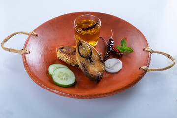 ilish panta Bengali new year festive dish. Boishakh panta ilish with green chilli and onion. Panta bhat is popular among Bengali's in India and Bangladesh. into clay plate seving bowl shanki or sanki