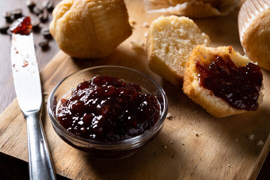 Muffins and raspberry jam on table