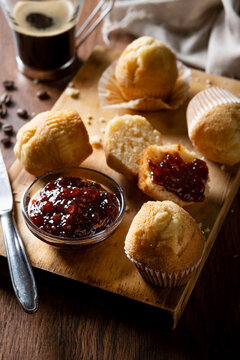 Muffins and raspberry jam on table