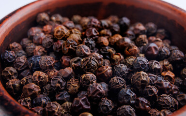Black pepper grains as background close up