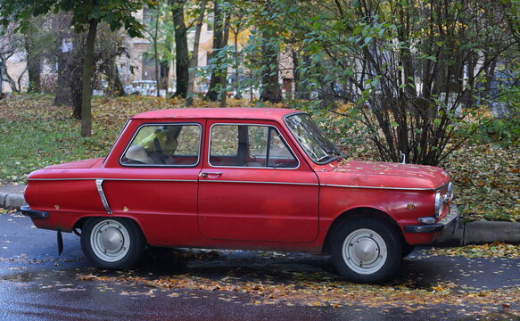 Old red restored car in the courtyard of the house, Tallinskaya Street, St. Petersburg, Russia, October 2022