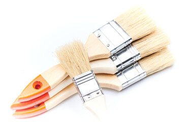 Fototapeta premium New clean wooden paint brushes isolated on white background closeup