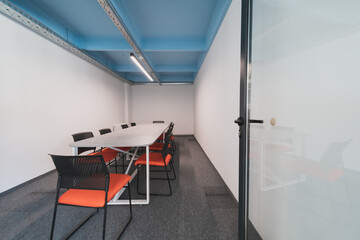 Interior of cozy light boardroom with table, modern stylish chairs and desktop computer, all ready...