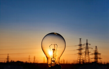 Light bulb with high voltage line on background. Electricity and energy savings in the city .
