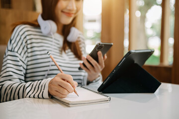 Woman hand working with new modern computer and writing on the notepad strategy diagram as concept