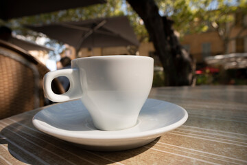 Closeup of an espresso cup on a table of a coffee shop in a village in south of France