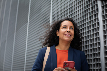 Businesswoman cycling to work using smartphone