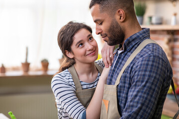 Very lovely couple have a perfect time together at the kitchen they cooking the dinner make the fresh and healthy salad woman hugging with passion her man. Happy and attractive guy while preparing