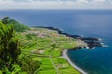 Beautiful scenery from a high point view of small houses in green field by the sea