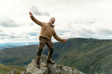 Bearded Man reaching the destination  and on the top of mountain  at sunset on autumn day  Travel  Lifestyle concept The national park Lake District in England