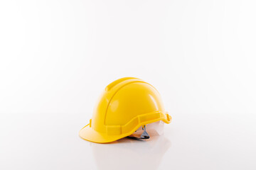 yellow safety helmet on white table and white background.