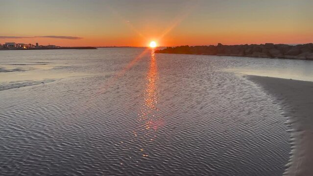 Orange sunrise with bluish waves at dawn