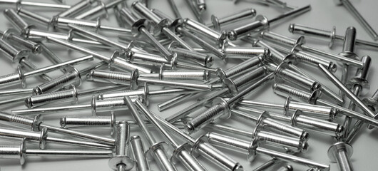 Rectangular background with aluminum rivets on the table. Sale of rivets in the store.Traction...