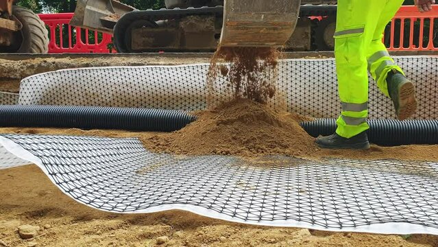 Groundworkers installing new electric ducts during roadworks	