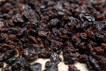 Dried black raisins in bowl with fresh organic grapes, background, selective focus