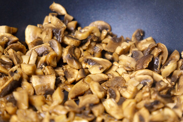 Cooking fried mushrooms, champignons in a pan. Close-up. Selective focus