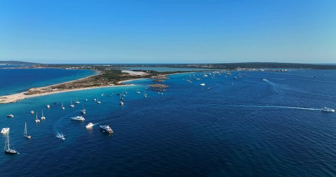 Aerial view of the beaches of Formentera island, Spain. Clear blue water of the Mediterranean Sea full of yachts.