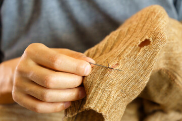 Hands men close-up. Mending clothes, sewing and darning, and fashionable needlework. Selective focus - obrazy, fototapety, plakaty