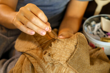 Mending clothes make, wear, repair, upcycle, swap, donate, recycle fashion concept. Selective focus. - obrazy, fototapety, plakaty